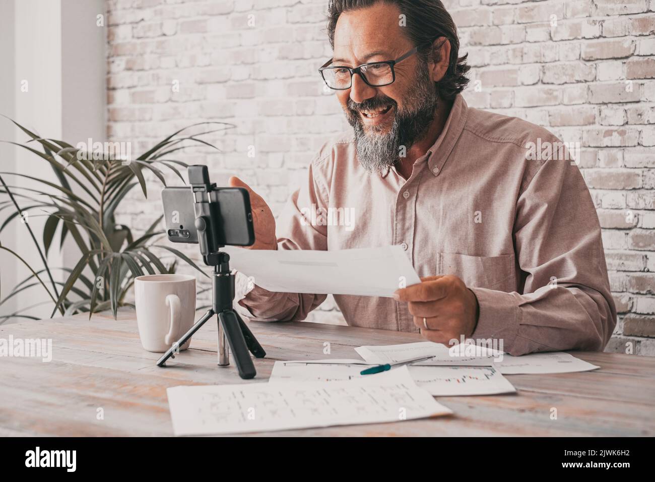 Ein Mann zeichnet Inhalte mit einem Mobiltelefon auf und lädt sie auf der Video-Kanal-Webseite hoch. Content Creator Menschen sprechen und sprechen mit Mobilfunk. Modern Stockfoto