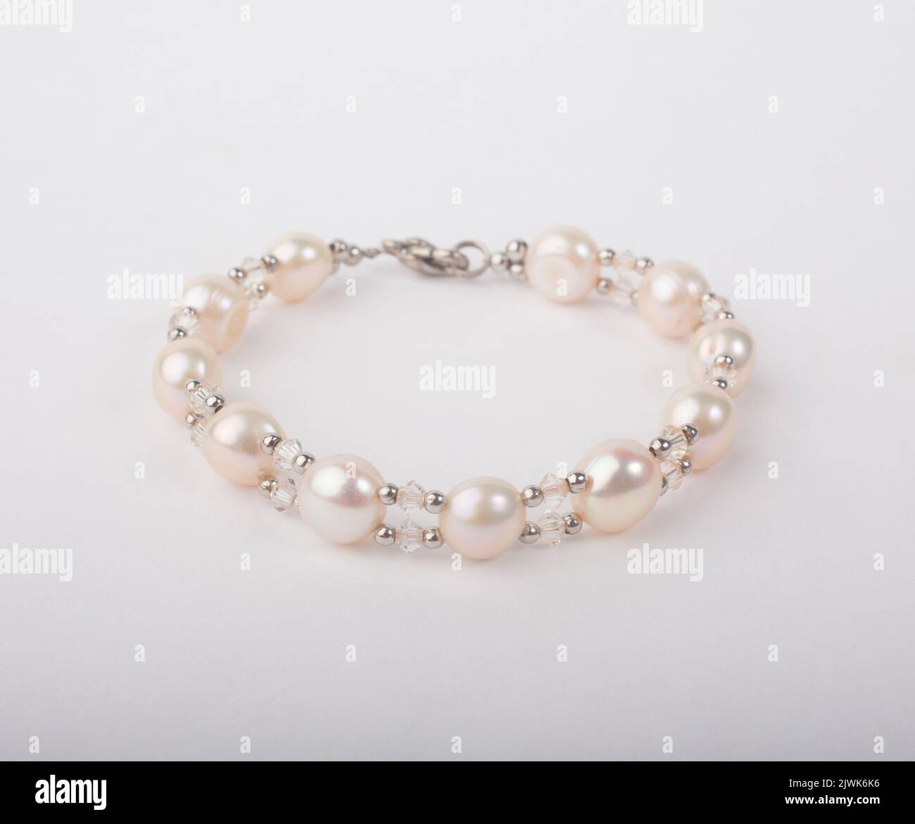 Echtes rosa Perlarmband mit Perle isoliert auf weißem Hintergrund verziert Stockfoto