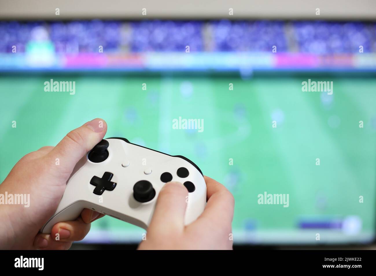 Spielt Fußball auf dem Fernseher, mit weißem Gamepad Stockfoto