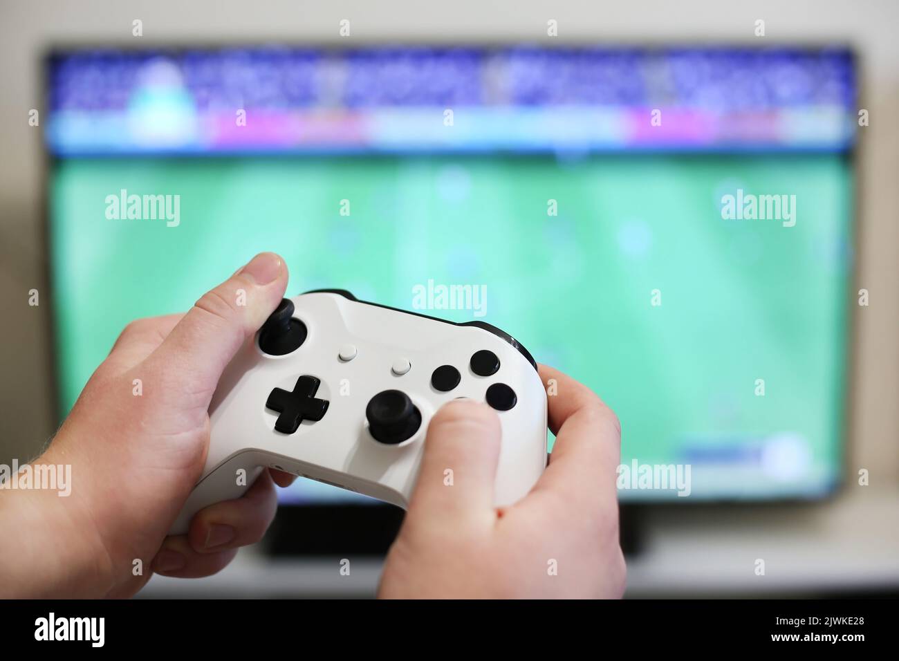 Spielt Fußball auf dem Fernseher, mit weißem Gamepad Stockfoto