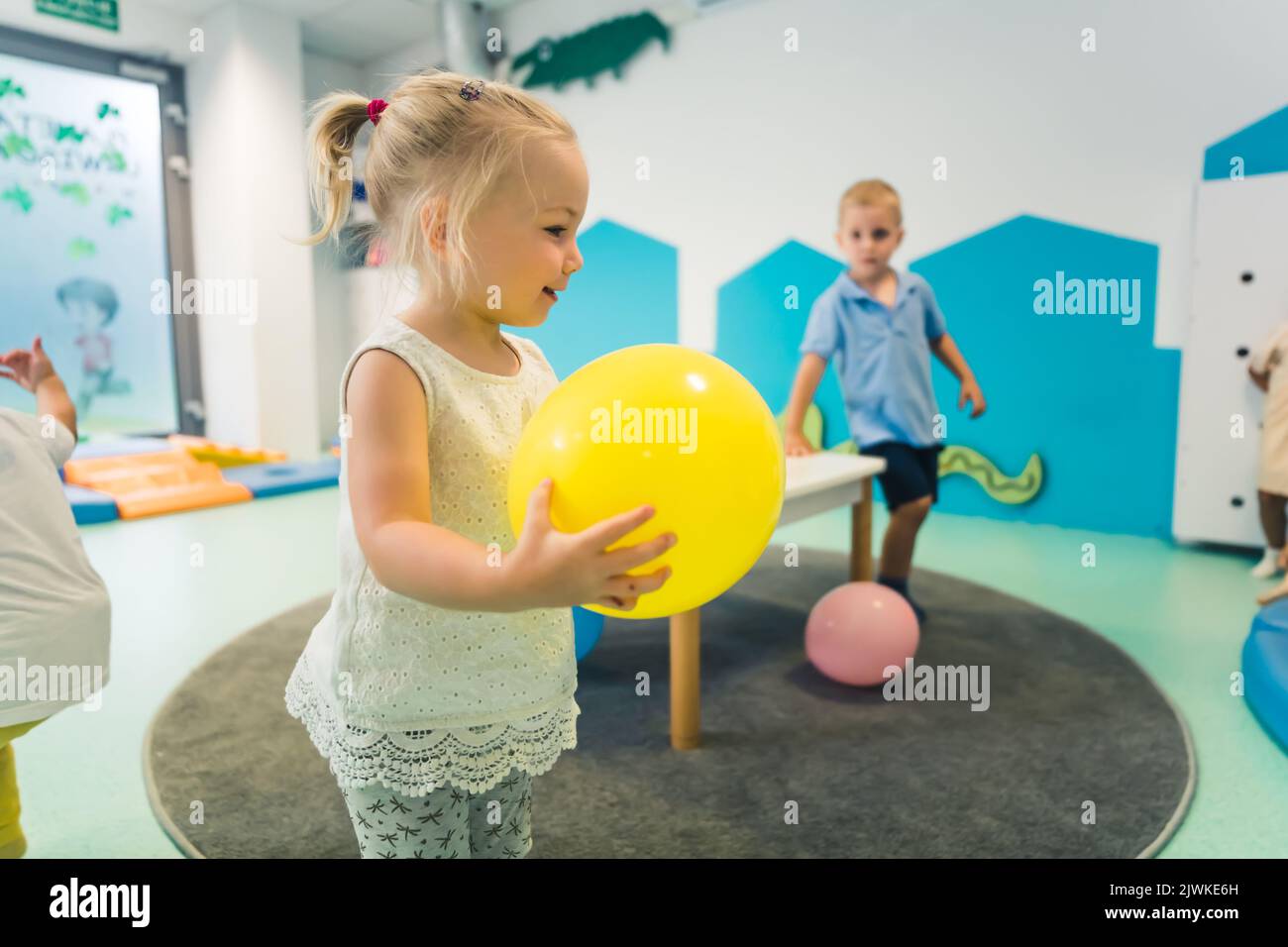Kleinkind kaukasischen Mädchen spielen bunte Ballons. Sensorisches Spiel im Kindergarten für Kinder Wellness. Hochwertige Fotos Stockfoto
