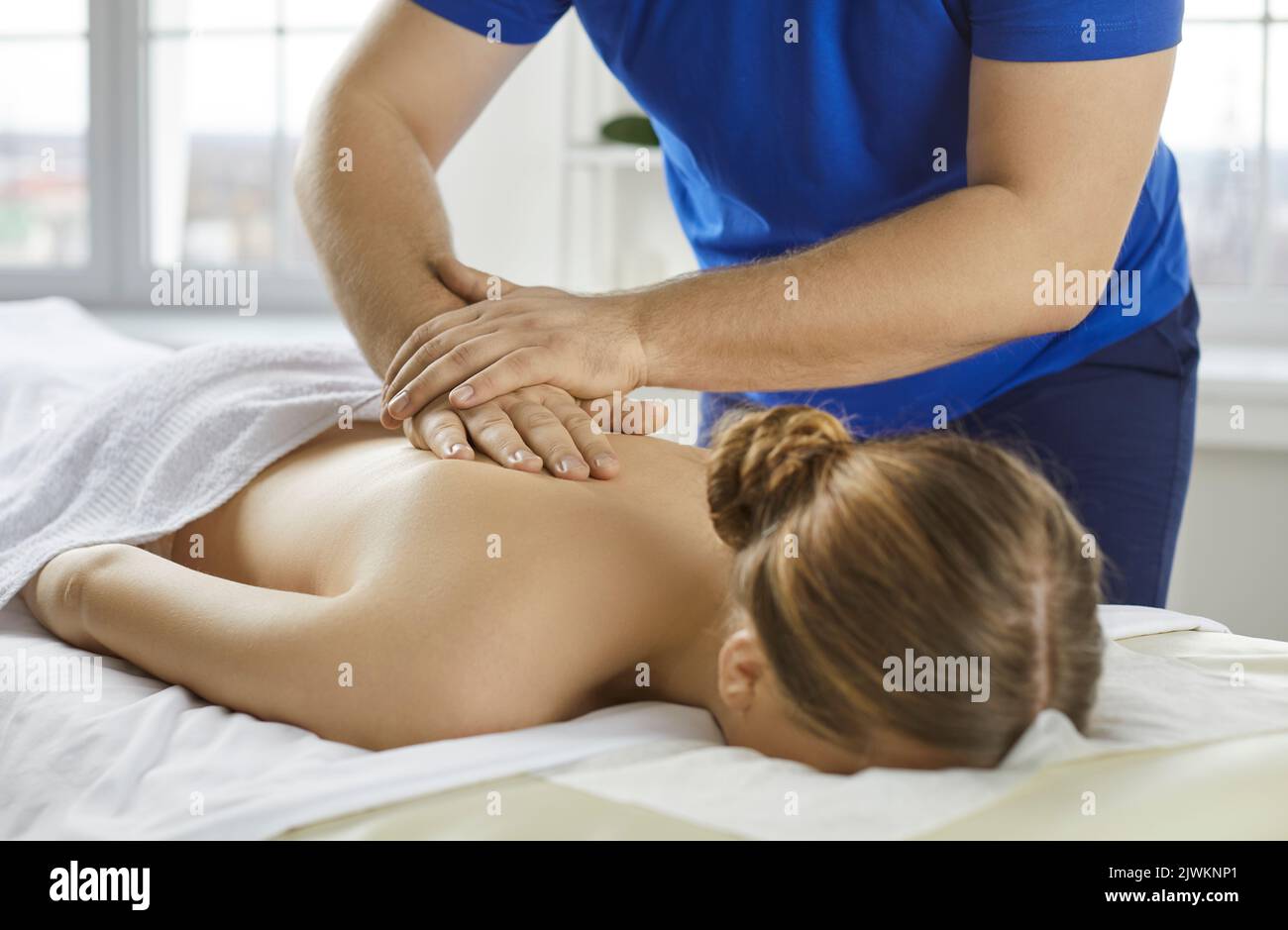 Männlicher Physiotherapeut massiert weiblichen Klienten zurück Stockfoto
