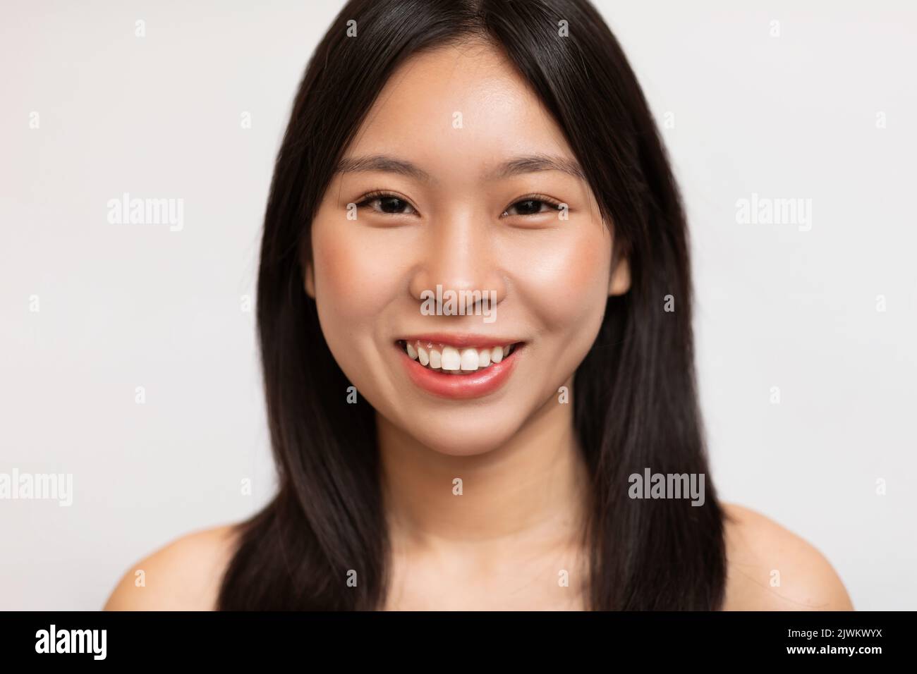 Natürliche Schönheit. Porträt der glücklichen koreanischen Dame mit natürlichen Make-up und gesunde glatte Haut posiert auf weißem Hintergrund Stockfoto