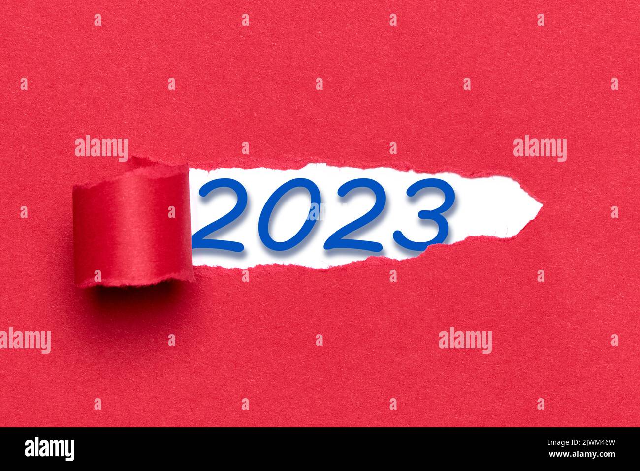 Die Zahl 2023 erscheint durch einen Riss in einem roten Karton ...