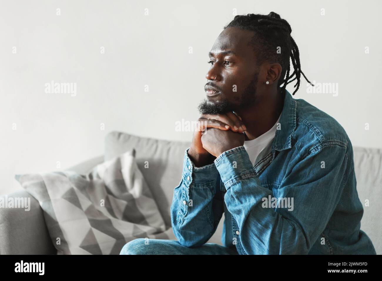 Ernster Afroamerikanischer Mann, Der Zu Hause Sitzt, Seitenansicht Stockfoto