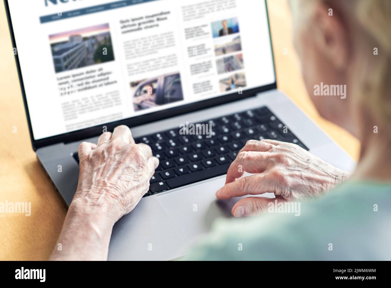 Nachrichten-Website in Laptop einer alten Frau. Älterer und Oma lesen digitale Zeitung mit Computer. Online-Magazin oder Webartikel auf dem Bildschirm. Stockfoto