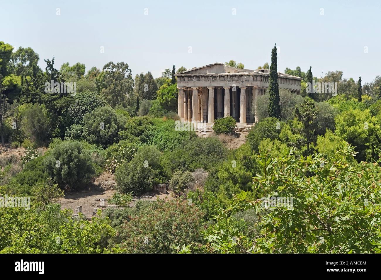 Blick auf den Tempel des Hephaestus auf dem Hügel Agoraios Kolonos, der von Grün bedeckt ist, in Athen, Griechenland Stockfoto