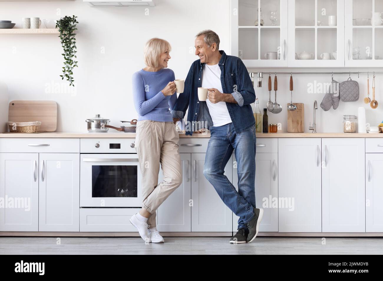 Glückliches Ehepaar im Homewear, das Kaffee in der Küche trinkt Stockfoto Glückliches Ehepaar im Homewear, das Kaffee in der Küche trinkt Stockfoto