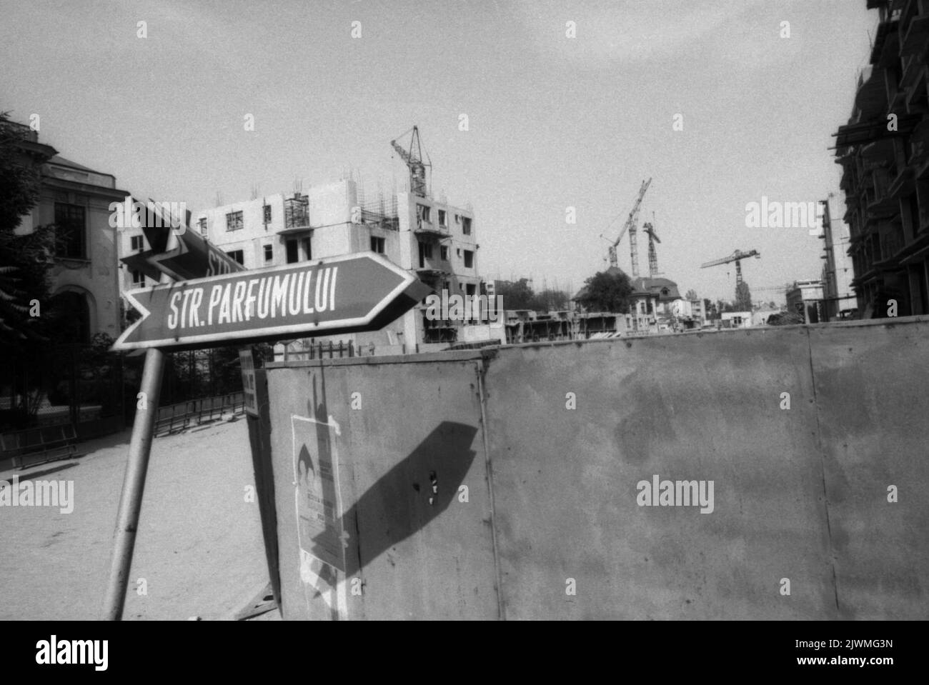 Bukarest, Rumänien, April 1990, ein paar Monate nach dem Fall des Kommunismus. Wohngebäude im sowjetischen Stil werden in einem historischen Viertel von wunderschönen, jahrhundertealten Häusern errichtet. Das Systematisierungsprojekt von Ceausescu ebnet viele historische Bezirke in der Hauptstadt. Einige alte Gebäude konnten dank der antikommunistischen Revolution kaum abgerissen werden. Straßenanzeige der Parfumului Street, einst ein hochwertiges Wohngebiet. Stockfoto