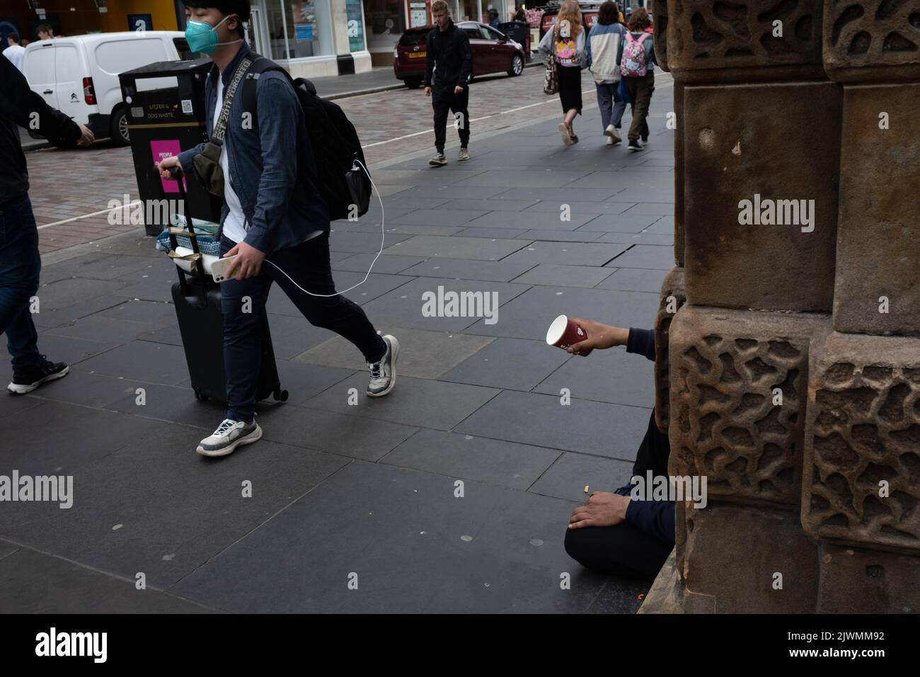 Ein Mann, der während der aktuellen Lebenshaltungskrise in Glasgow, Schottland, am 6. September 2022, eine Einweg-Kaffeetasse aushält, während er um Geld bittet. Stockfoto