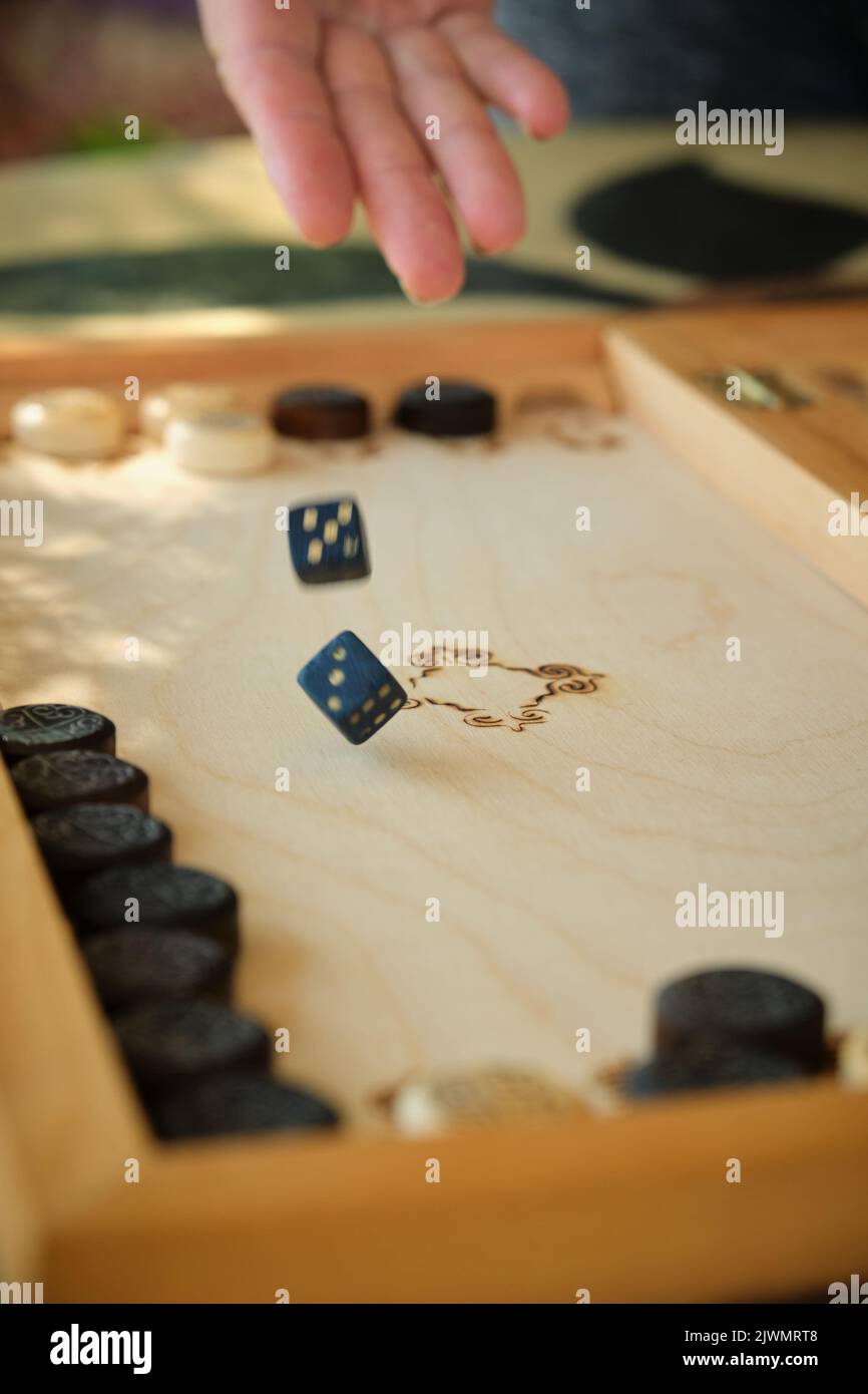 Backgammon Board mit Chips und Würfeln im Flug Stockfoto
