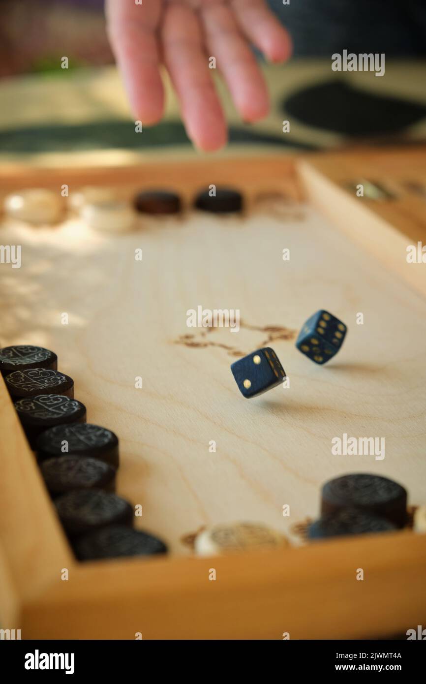 Backgammon Board mit Chips und Würfeln im Flug Stockfoto