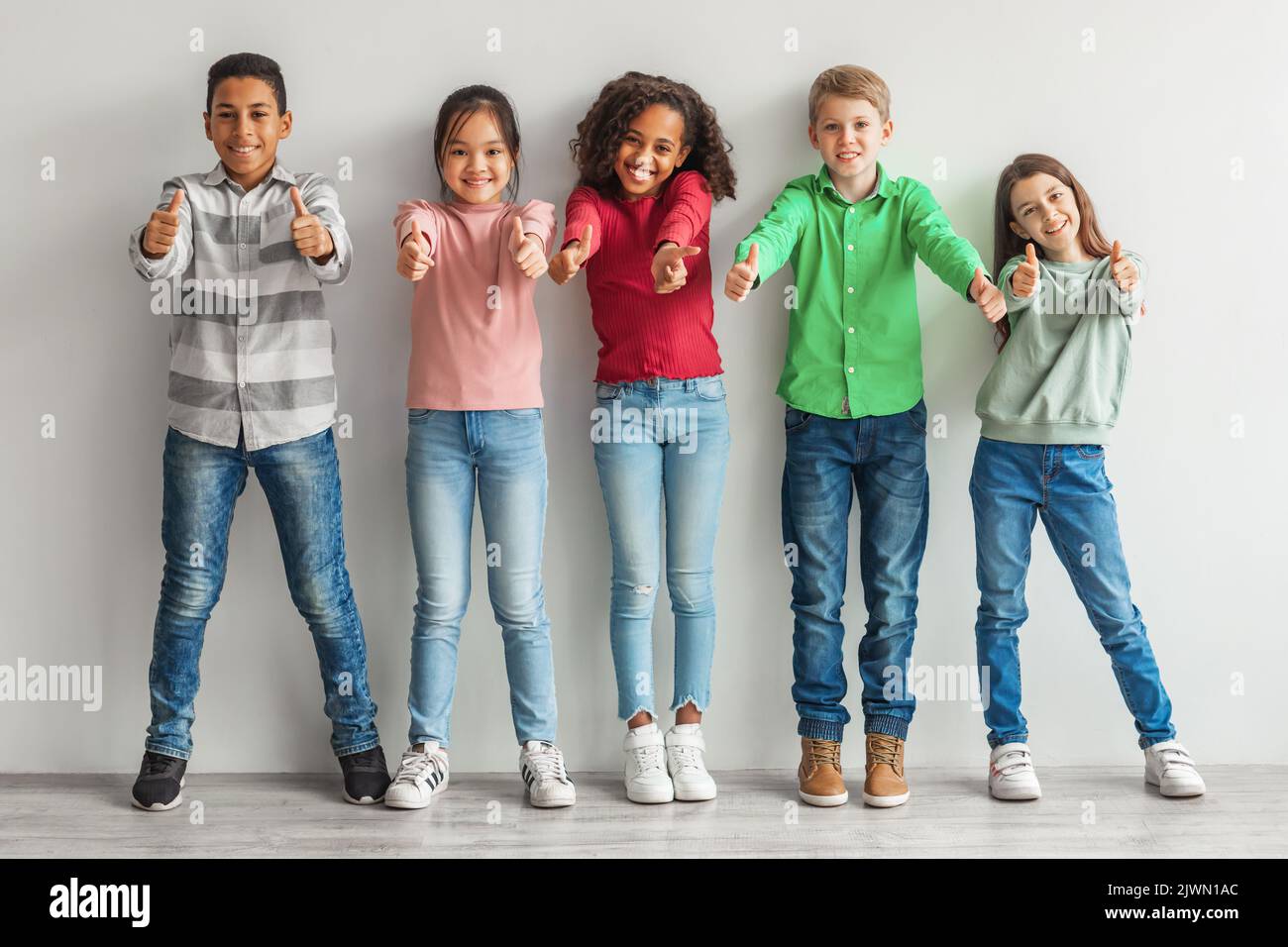 Gruppe Von Glücklichen Verschiedenen Kindern Gestikulieren Daumen Nach Oben Indoor Stockfoto
