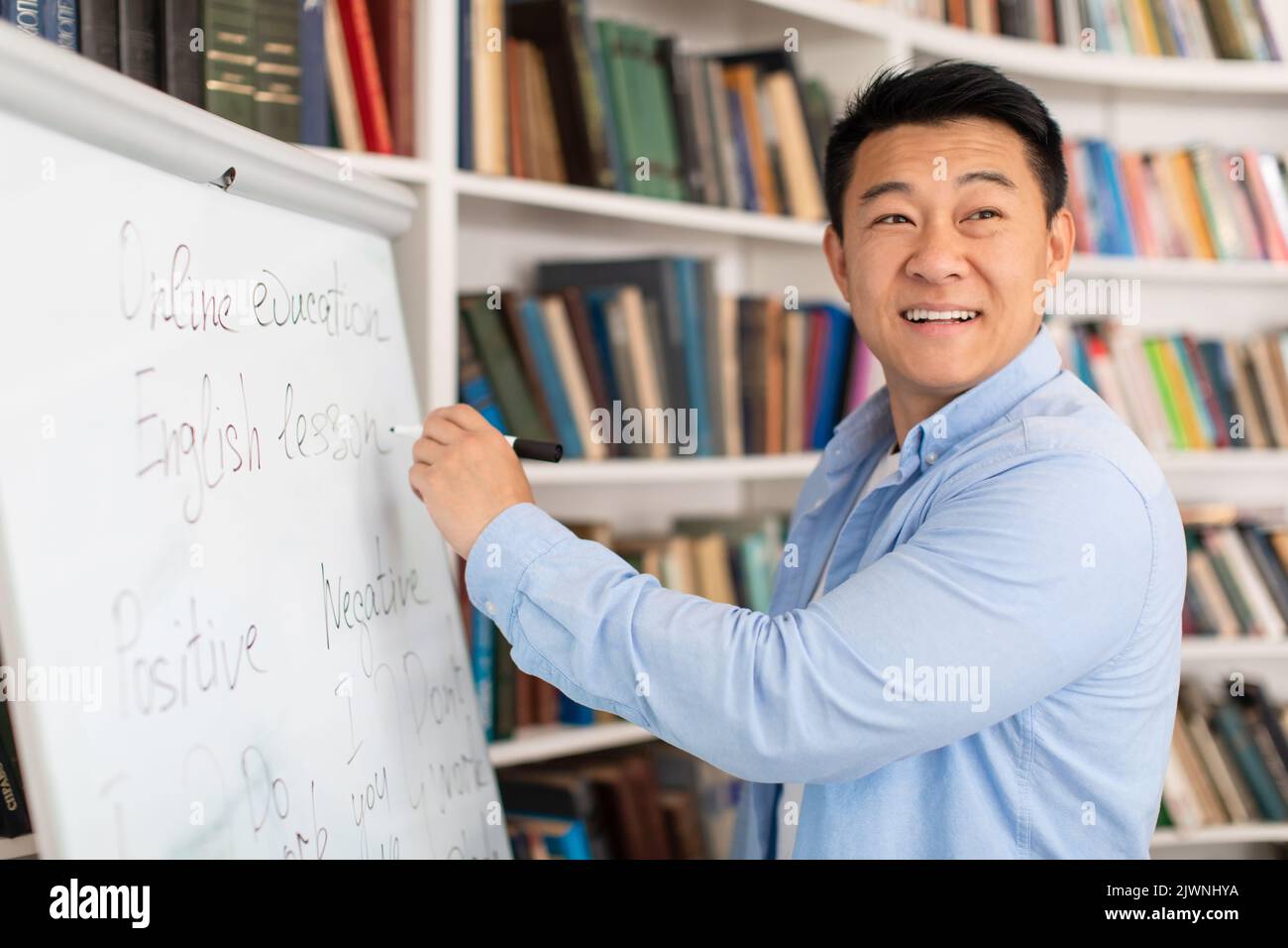 Japanisch Männlich Lehrer Schreiben Auf Whiteboard Lehre Stehen Im Klassenzimmer Stockfoto