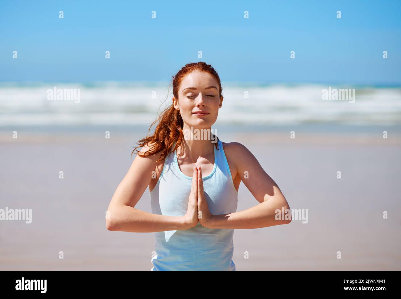 Wenn Sie Ihren Atem besitzen, kann niemand Ihre Ruhe stehlen. Eine junge Frau praktiziert ihre Yoga-Routine am Strand. Stockfoto