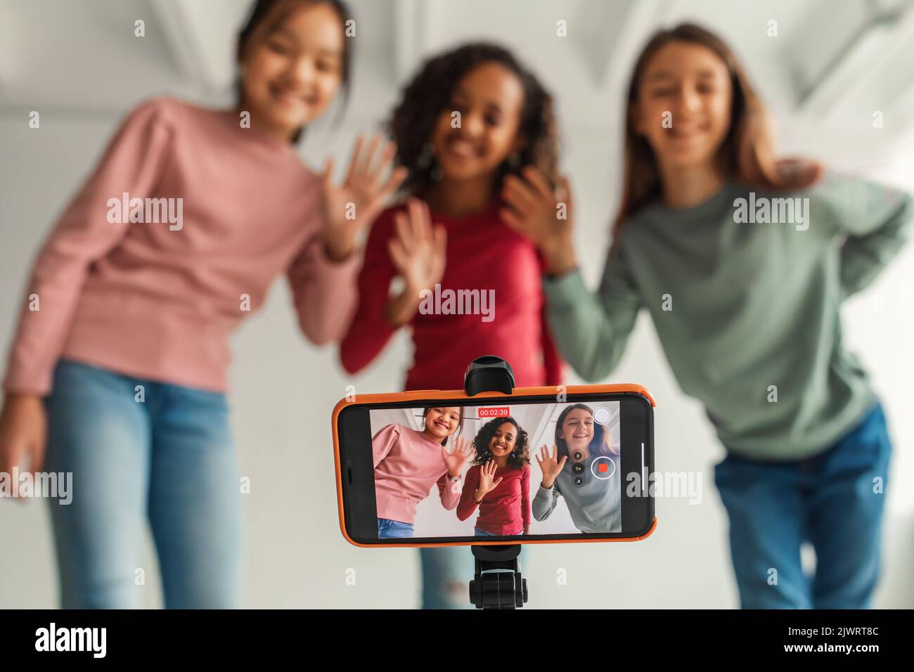 Drei Mädchen Winken Bis Telefon Machen Video Für Blog Innen Stockfoto