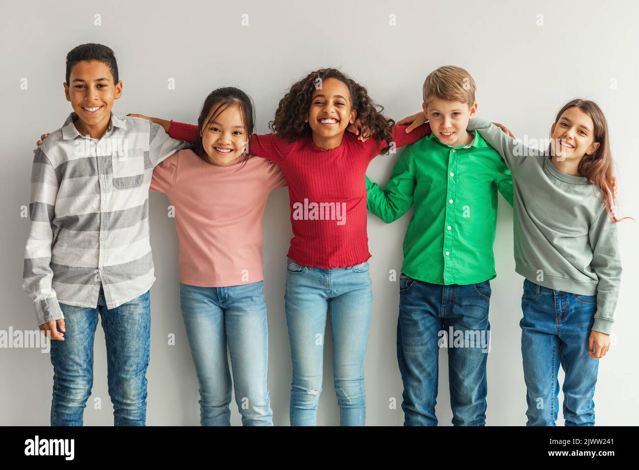 Fröhliche Multiethnische Kinder Umarmen Sich Und Lächeln Vor Camera Indoors Stockfoto