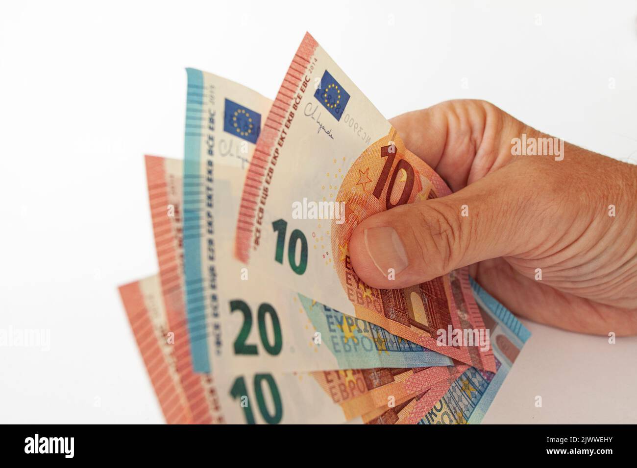 Handhaltung von Euro-Banknoten. Nahaufnahme des Bildes auf weißem Hintergrund isoliert. Ausgaben und Einkommen in europäischen Ländern.Euro-Wechselkurse r Stockfoto