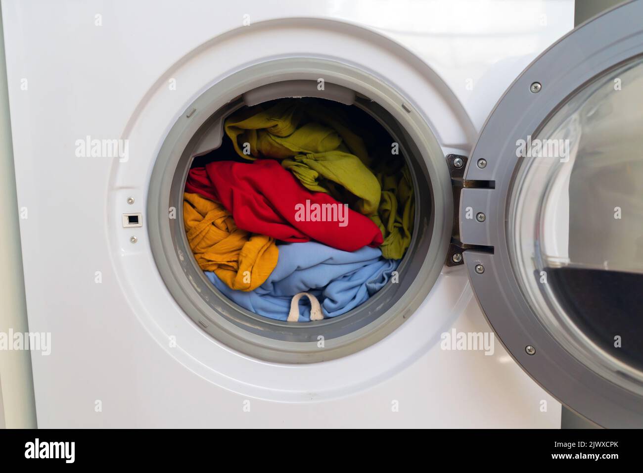 Helle Kleidung in der Waschmaschine. Stockfoto