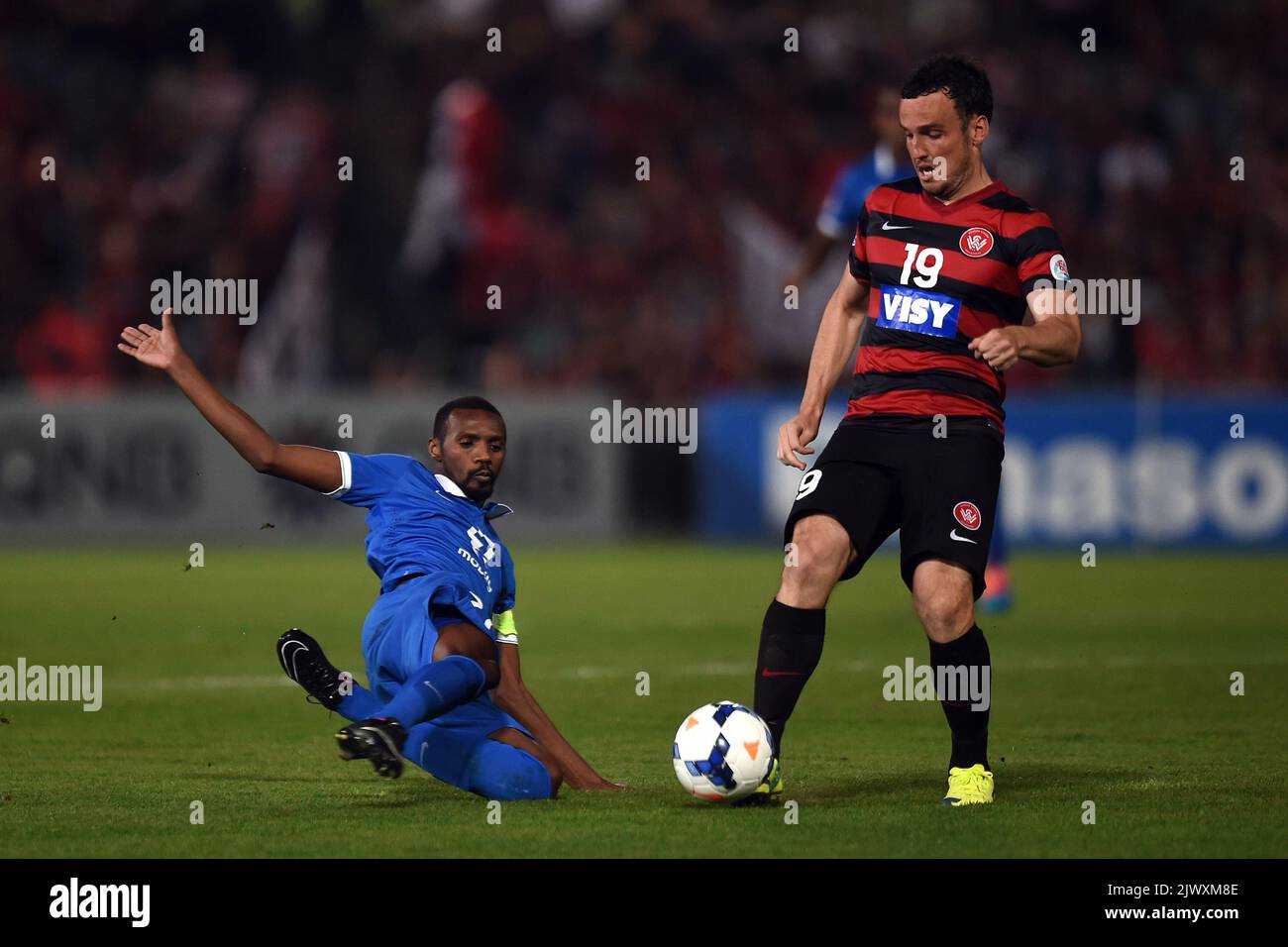 Die Western Sydney Wanderers' Marck Bridge (rechts) wird von Saud Kariri vom FC Al-Hilal während der ersten Etappe des AFC Champions League Finales am Samstag, den 25. Oktober 2014 im Parramatta Stadium in Sydney angegangen. (AAP-Bild/Paul Miller) Stockfoto