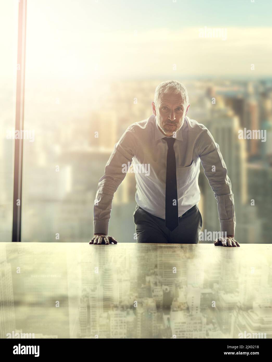 Ich Laufe diese Stadt. Zugeschnittenes Porträt eines reifen Geschäftsmannes, der in seinem Büro vor einem Stadtbild steht. Stockfoto