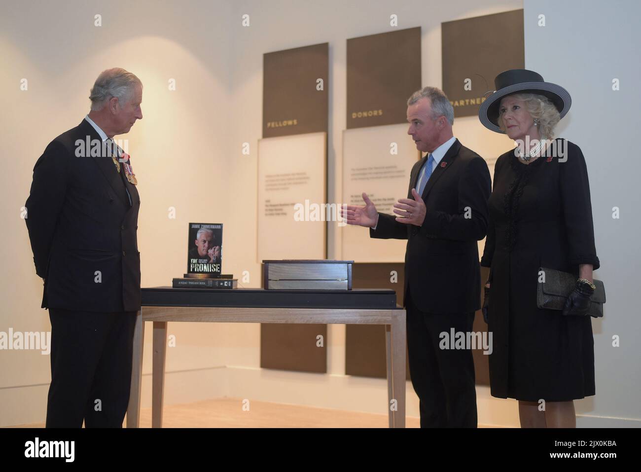 Der britische Prinz Charles (links) und seine Frau Camilla, die Herzogin von Cornwall, erhalten am Mittwoch, den 11. November 2015, ein Geschenk, das der Direktor des Australian war Memorial Brendan Nelson während der gedenkfeiern zum Gedenken an den Gedenktag im Australian war Memorial in Canberra überreicht hat. Der Prinz und die Herzogin legten während der Gedenkfeiertage einen Kranz am Grab des unbekannten Soldaten nieder. (AAP-Bild/Lukas Coch) Stockfoto