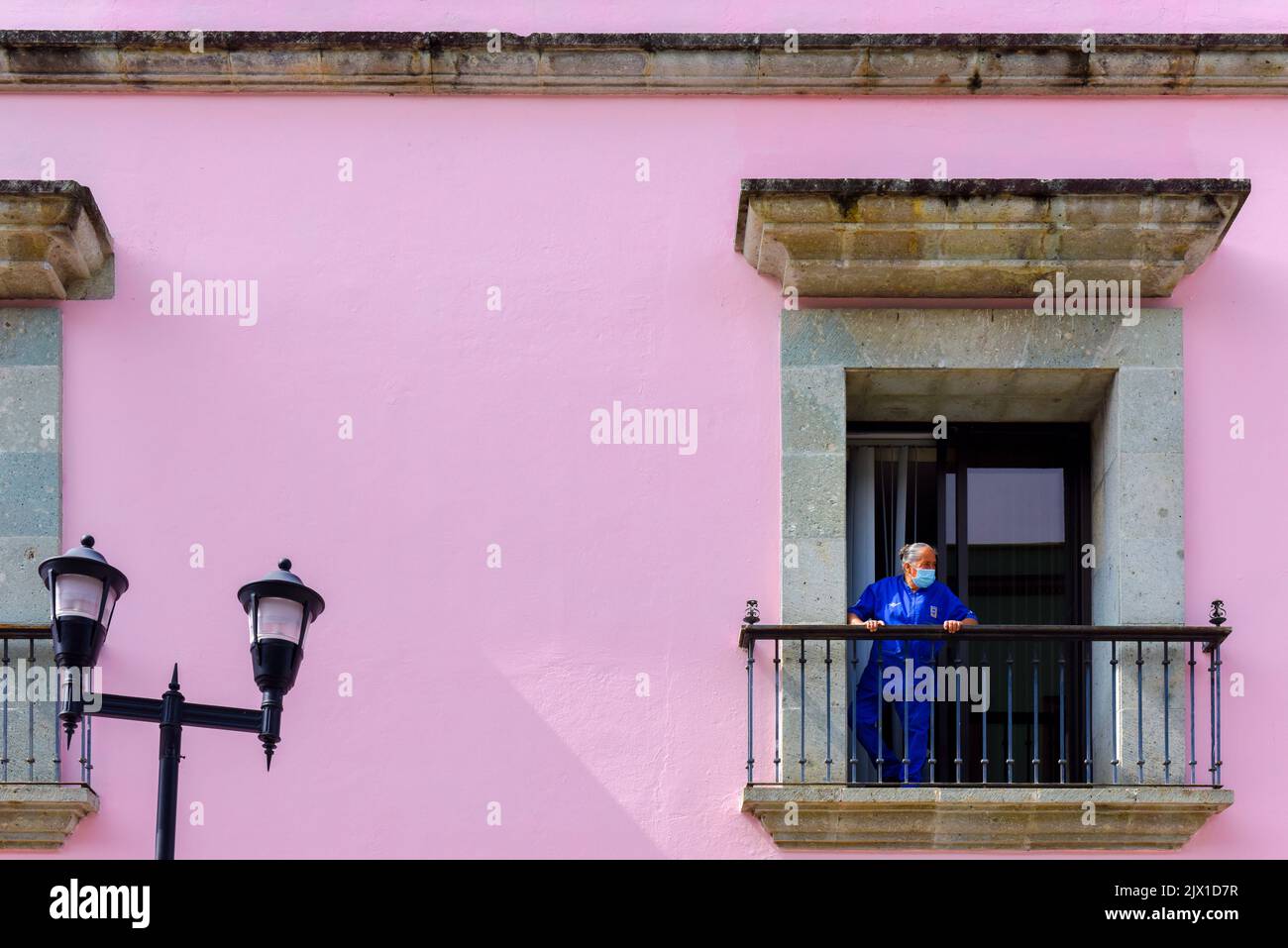 Arbeiter, der auf einem Balkon eines Kolonialgebäudes in Oaxaca de Juarez, Bundesstaat Oaxaca, Mexiko, steht Stockfoto
