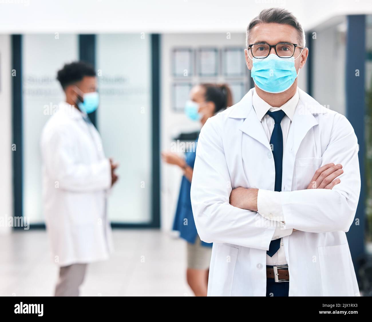 Maske, Covid und Medizin mit einem Mann Arzt trägt eine Maske in einem Krankenhaus für Sicherheit, Gesundheit und Wellness. Gesundheitswesen, Medizin und Versicherung mit einem Mann Stockfoto