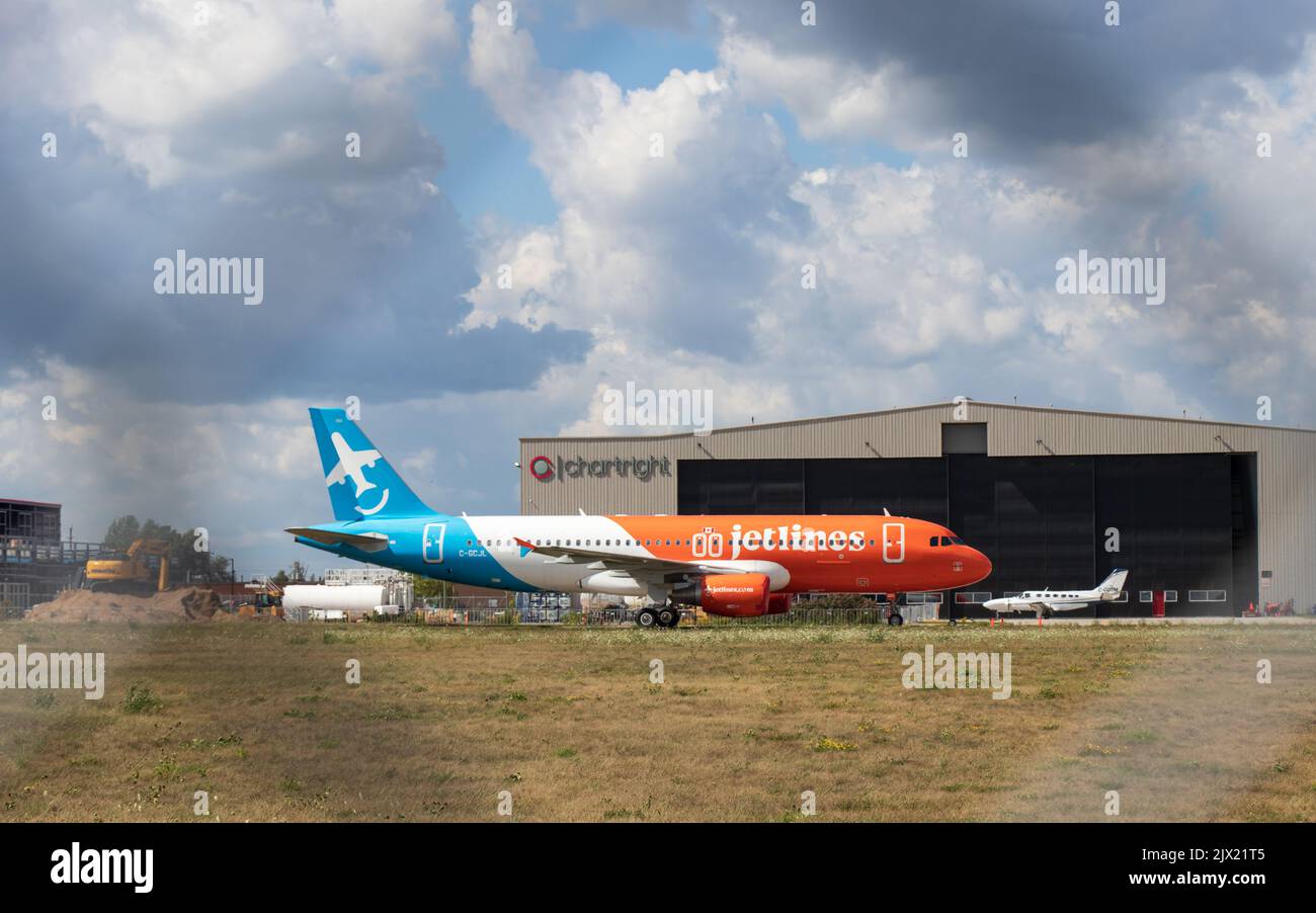 Das erste Flugzeug von Canada Jetlines A320 ist durch den Flughafenzaun im Fokus, während es auf einem Flughafen parkt und auf seinen ersten kommerziellen Service-Flug wartet. Stockfoto