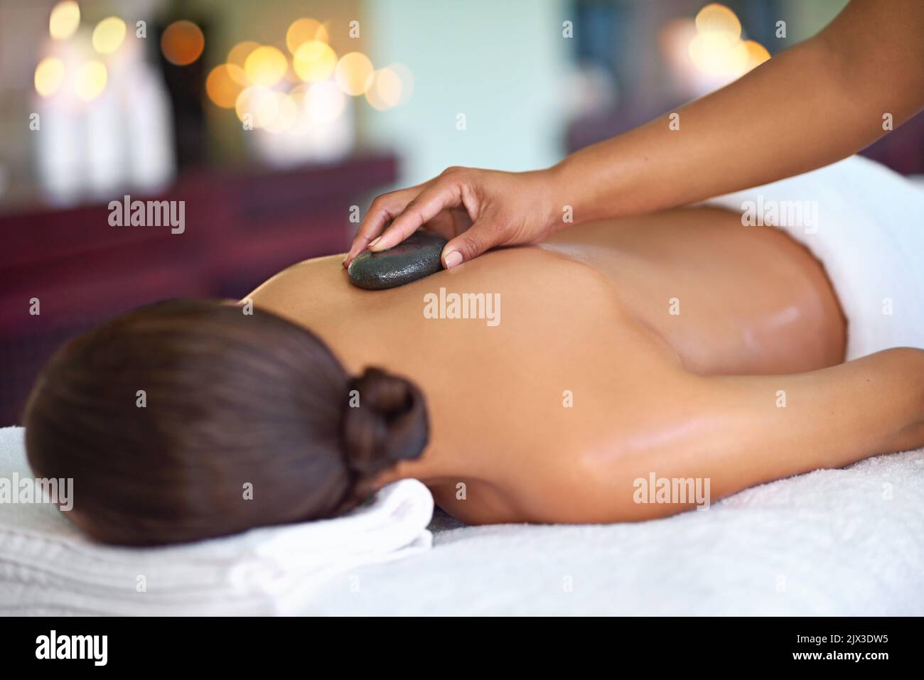Sei still. Eine junge Frau genießt eine Hot Stone Massage in einem Spa. Stockfoto