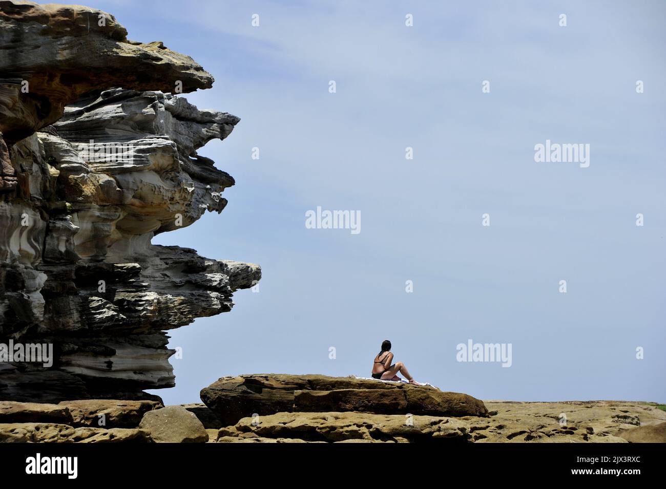 Am Dienstag, den 13. Dezember 2016, backt eine Frau auf den Felsen bei North Bondi in Sydney. Sydney, Canberra, Melbourne und Adelaide sind von der Sommerhitze heimgesucht, die Temperaturen haben sich über 30C erhöht. (AAP-Bild/Joel Carrett) Stockfoto