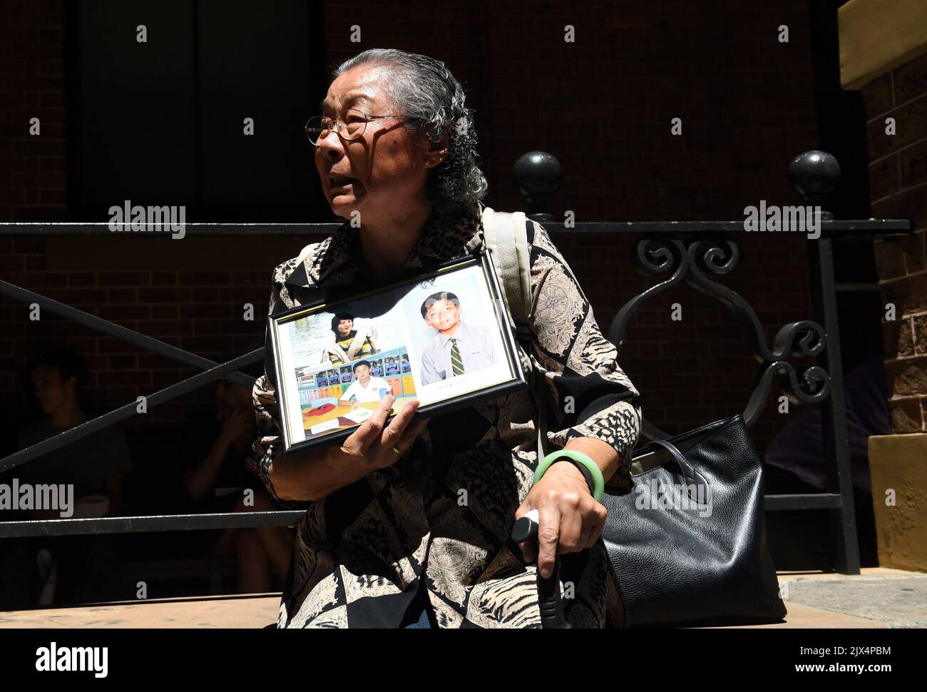 Feng Qing Zhu, die Großmutter und Mutter von Mitgliedern der verstorbenen Familie Lin, hält ein Familienporträt, als sie am Montag, den 13. Februar 2017, den Obersten Gerichtshof von NSW in Sydney verlässt. Ihr Schwiegersohn, Lian bin 'Robert' Xie, wurde für schuldig befunden und zu fünf lebenslangen Haftstrafen verurteilt, ohne die Möglichkeit einer Bewährung für den Mord an fünf Mitgliedern der Familie seiner Frau in den Schlafzimmern ihres Hauses in North Epping im Juli 2009. (AAP-Bild/Paul Miller) Stockfoto