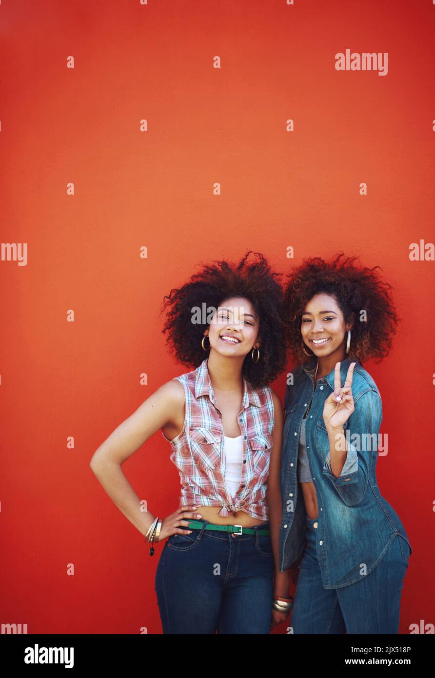 Meine Bestien die beste aller Zeiten. Zwei junge Freunde posieren vor rotem Hintergrund. Stockfoto