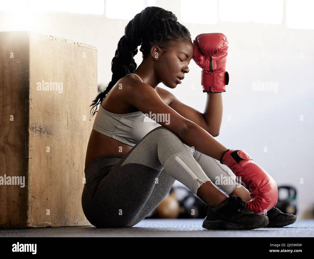 Sport-, Fitness- und Frauenboxerin auf dem Boden eines Fitnessraums. Schwarzer Athlet, der während eines mit geringer Energie erschöpft aussieht Stockfoto