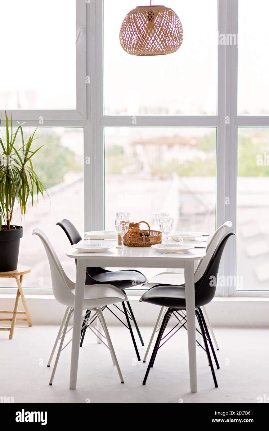 Modernes Interieur einer gemütlichen Küche im Esszimmer, weiße Möbel, vor dem Hintergrund eines Panoramafensters. Konzeptionelles Dekor, Haushypothek Stockfoto
