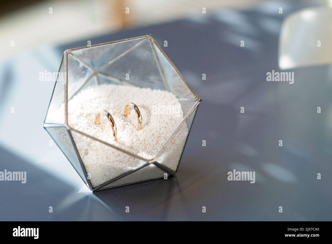 Ein Paar schöner Eheringe in einem modernen Glasständer. Ehe, Zeremonie. Weicher, selektiver Fokus. Stockfoto