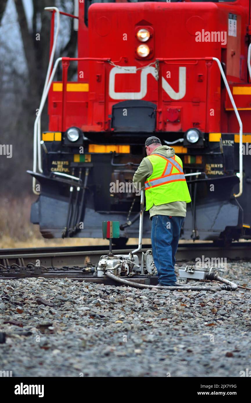 Bartlett, Illinois, USA. Ein Zugbesatzungsmitglied wirft einen Schalter, der einen lokalen Güterzug mit Zugang zu einem Industriegleis versorgt. Stockfoto