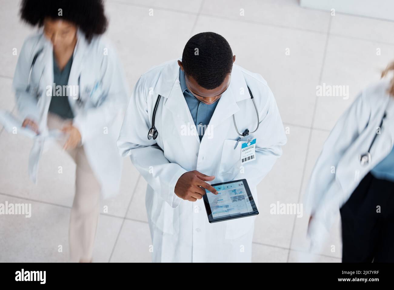 Arzt, digitaler Tablet-Test und medizinisches Personal mit Labordaten zur Technologie in einem stark frequentierten Krankenhaus von oben. Gesundheitsfürsorge, arbeitende Menschen und Stockfoto