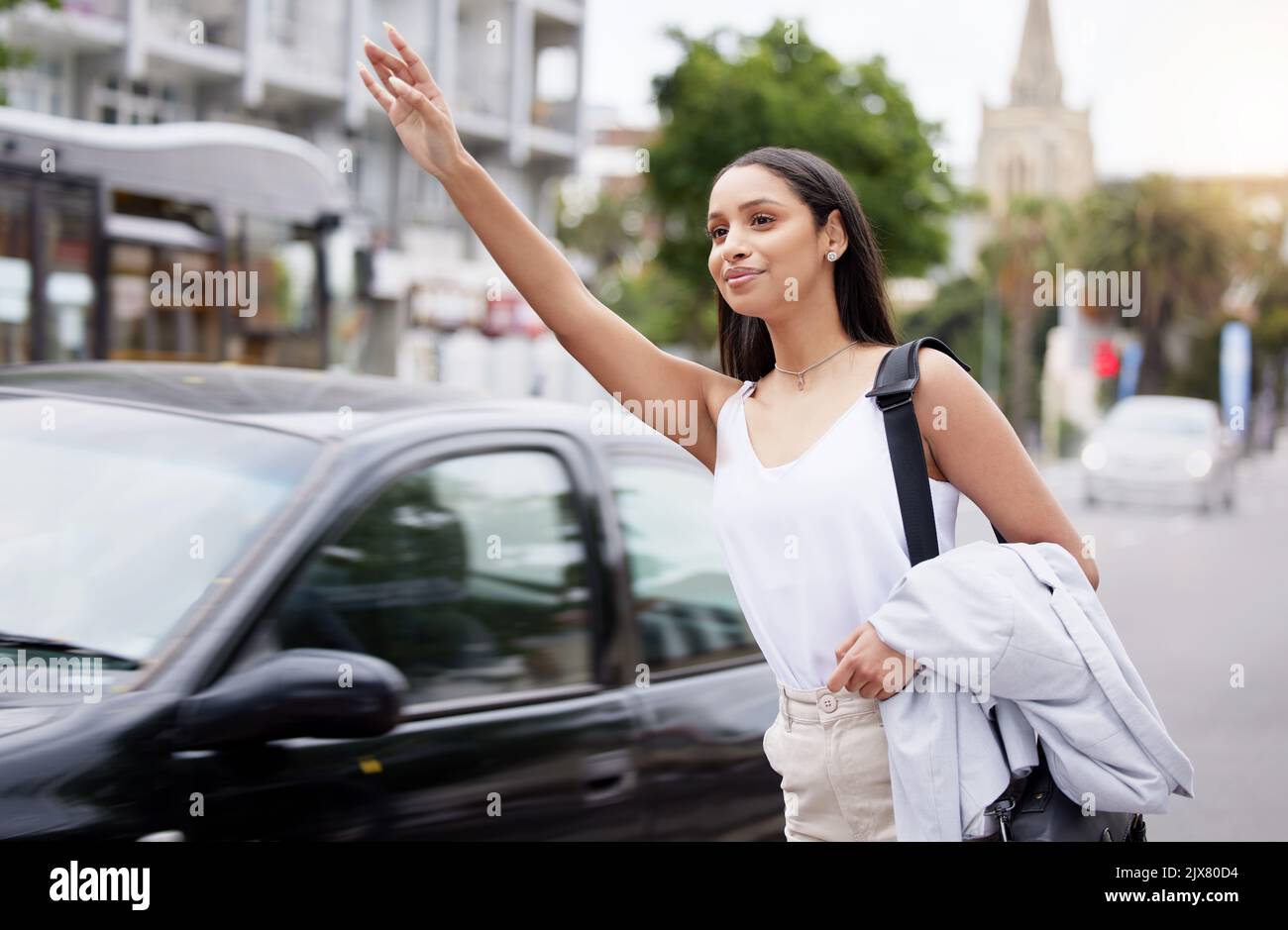 Geschäftsfrau ruft morgens ein Taxi oder einen Transport auf der Straße der Stadt, während sie zur Arbeit pendeln. Freundliche Angestellte winken Hand und Arm für ein Taxi Stockfoto