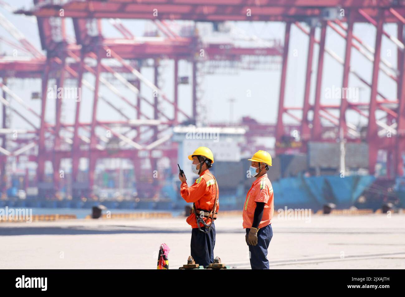 LIANYUNGANG, CHINA - 7. SEPTEMBER 2022 - Hafenarbeiter leiten das Be- und Entladen von Containern am Qianwan Foreign Trade Container Terminal von Stockfoto