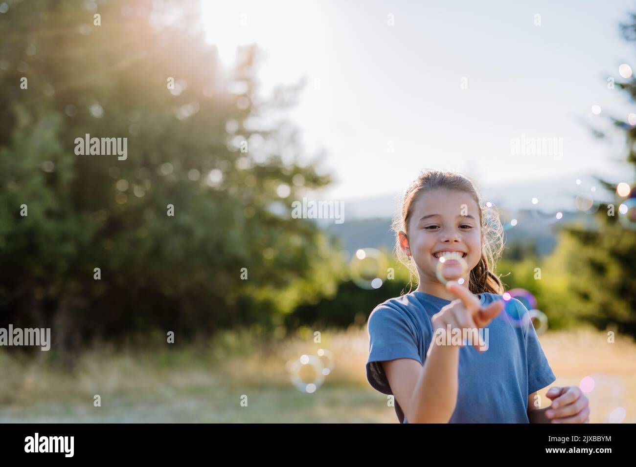 Kleines Mädchen Spaß beim Blasen Seifenblasen an einem Sommertag in der Natur. Stockfoto