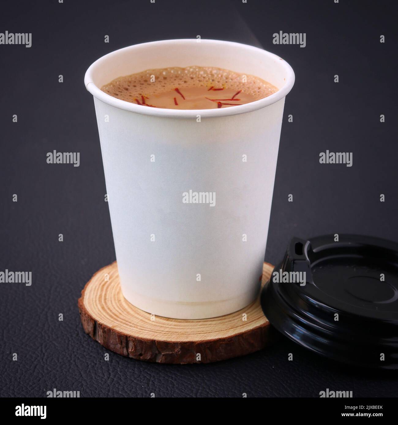 Teetasse voller Tee auf einem Stück Holz lizenzfreies Stock Foto, Bild Stockfoto