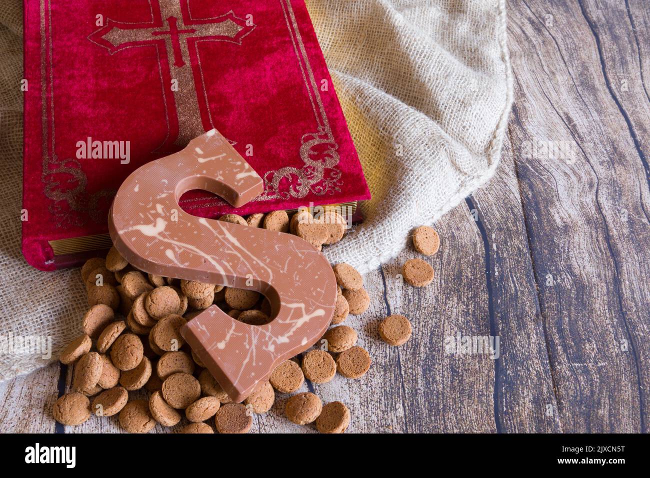 Holländische Sinterklaas Tradition: Ein Schokoladenbrief, das Buch Sinterklaas, eine Tüte und Süßigkeiten genannt Pepernoten. Stockfoto