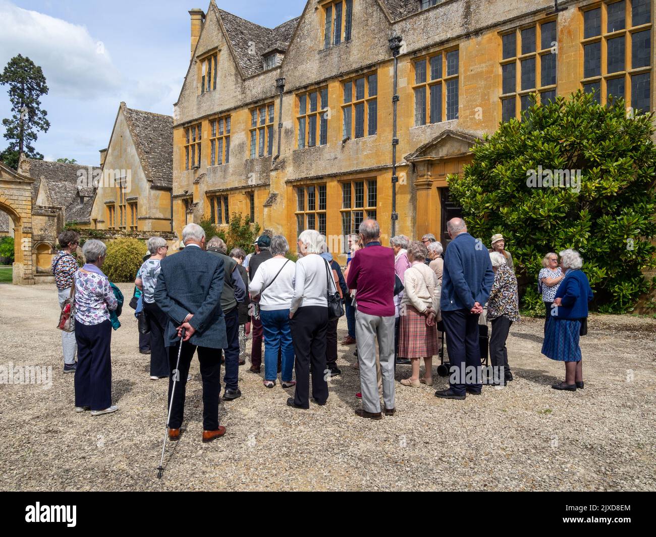 Außenansicht des Stanway House, einem jakobischen Herrenhaus aus dem 16.. Jahrhundert, Stanway, Cotswolds, Gloucestershire; mit einer Gruppe von älteren Besuchern Stockfoto