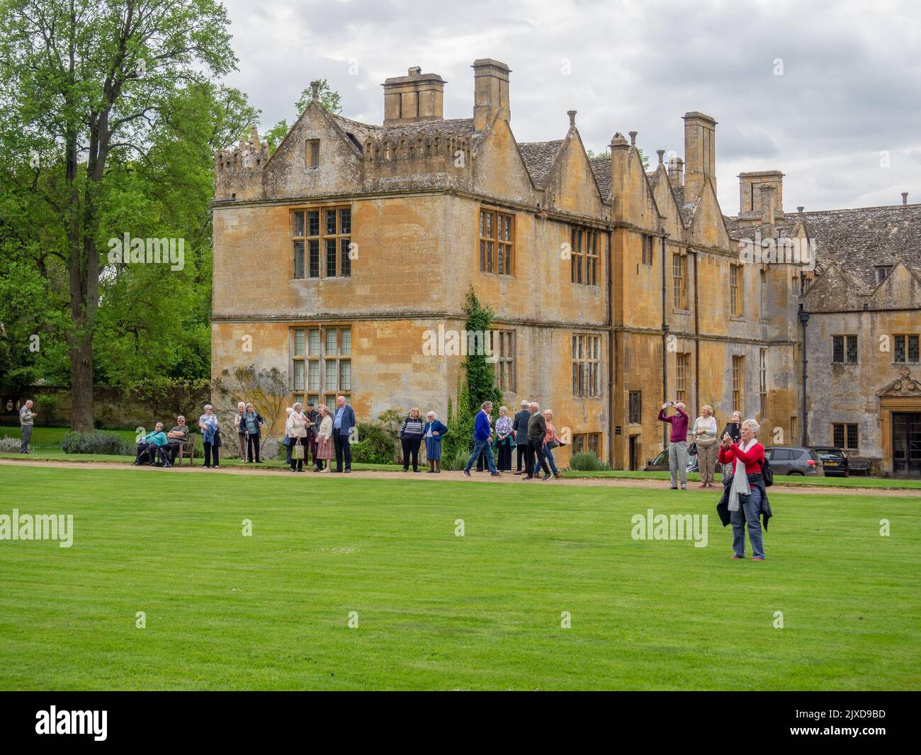 Außenansicht des Stanway House, einem jakobischen Herrenhaus aus dem 16.. Jahrhundert, Stanway, Cotswolds, Gloucestershire; mit einer Gruppe von älteren Besuchern Stockfoto