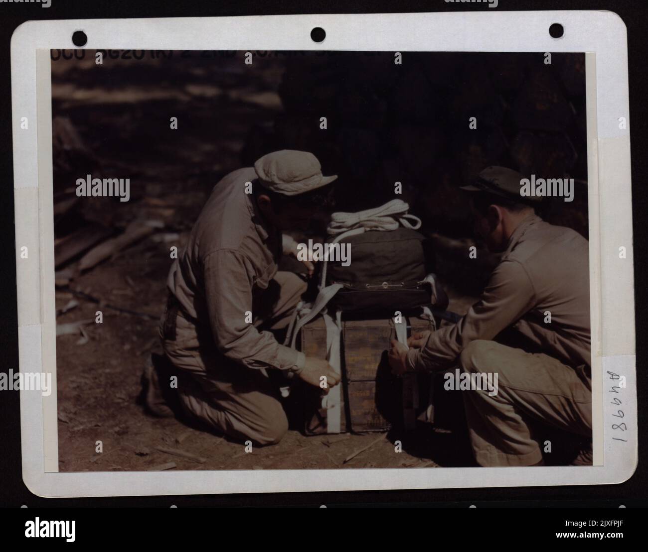 Packer von 2. Truppenteilen Carrier Squadron von 10. AF Eastern Air Command, befestigen Einen Fallschirm an 30 Cal. Munitionsfälle, die von der USAAF C-47S fallen gelassen werden. Stockfoto