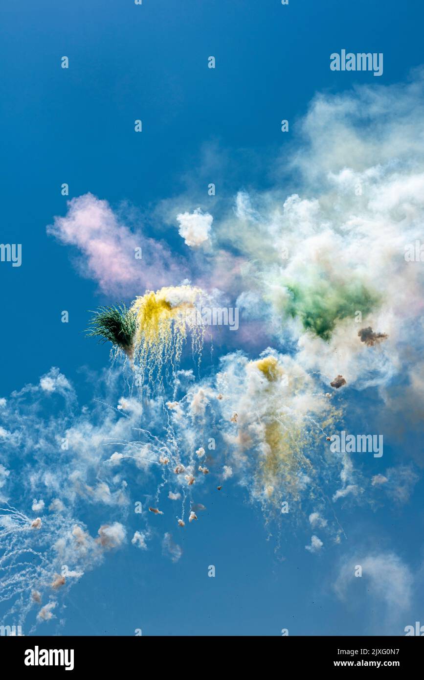 Ein Feuerwerk, das bei hellem Tageslicht gegen einen blauen Himmel explodiert, markiert ein religiöses Fest in einem sizilianischen Dorf Stockfoto