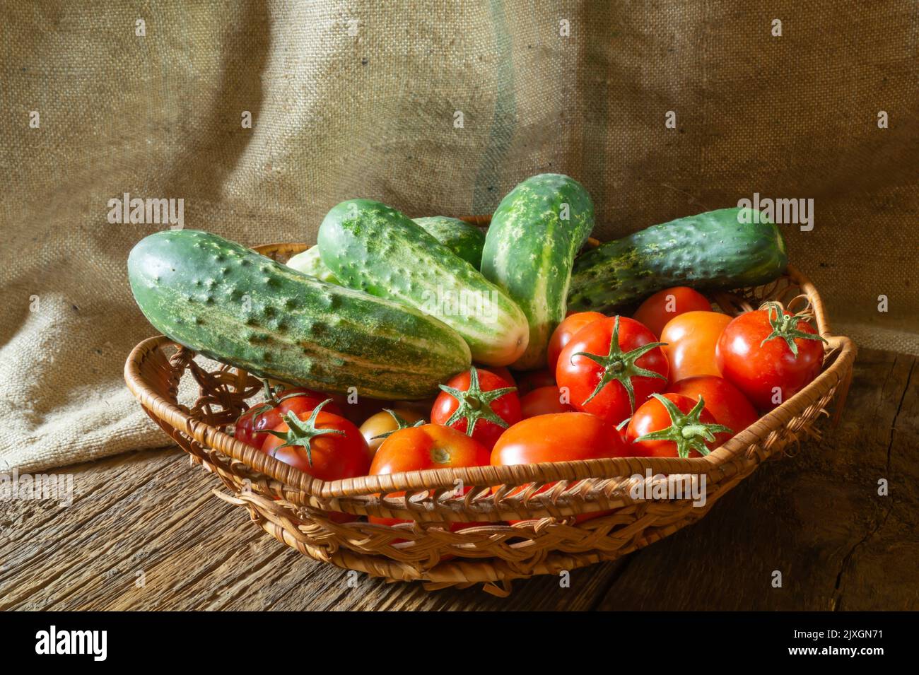 Gemüse auf dem Hintergrund der Sackleinen Nahaufnahme. Lebensmittel im Korb. Sommerernte auf dem Tisch Stockfoto