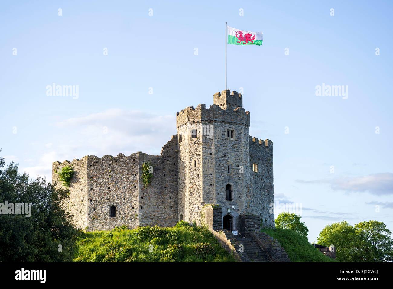 Cardiff Castle an einem klaren Tag mit blauem Himmel und walisischer Flagge in Cardiff, Großbritannien. Stockfoto