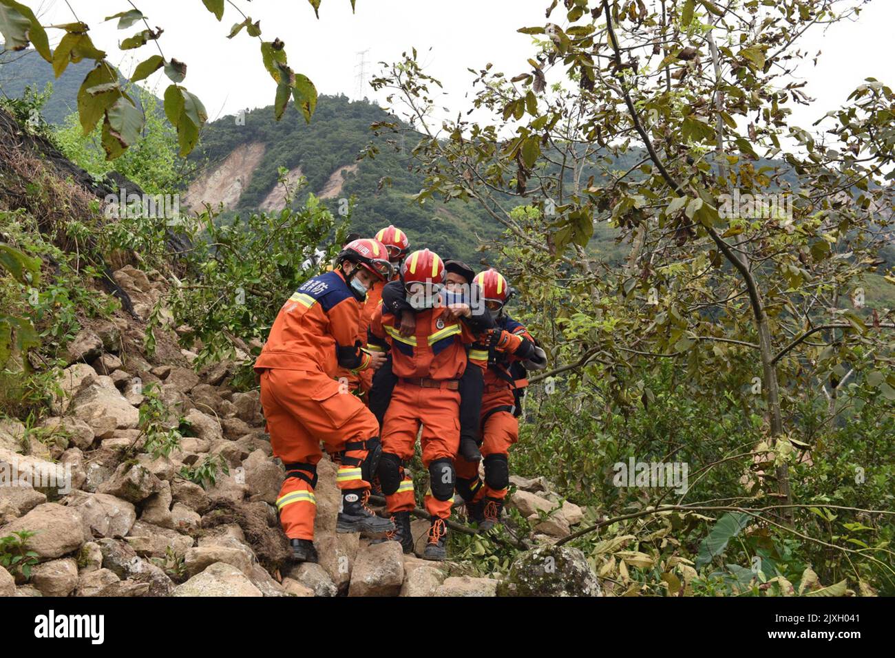 LUDING, CHINA - 7. SEPTEMBER 2022 - Feuer- und Rettungskräfte der Präfektur Ganzi tragen verletzte ältere Menschen auf einem Berg im Dorf Ziyachang Stockfoto